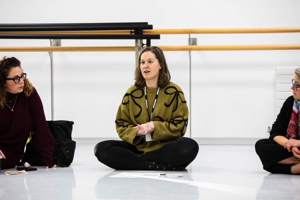 Group of students participating in a creative arts workshop at Suffolk New College, engaging in discussion and learning new skills through collaboration with local arts organisations.