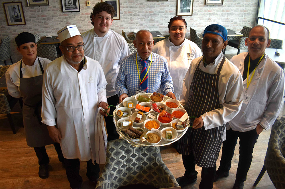 Suffolk students with Curry King from Manningtree, showcasing diverse chefs and culinary skills in a professional kitchen setting.