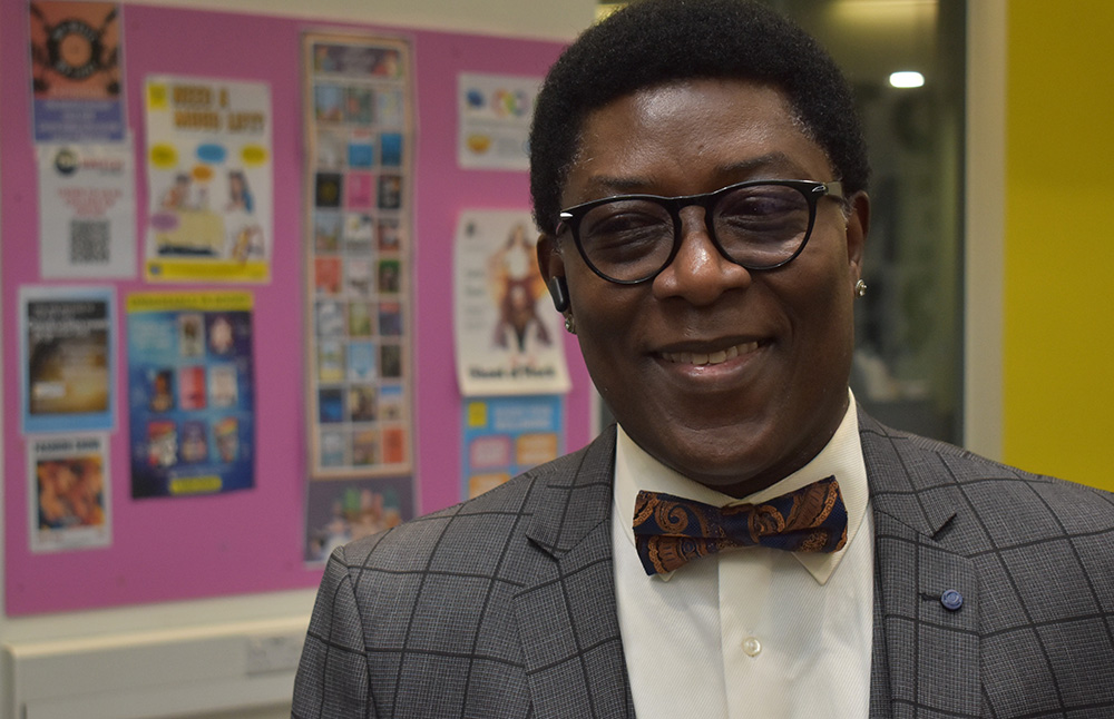 Smiling man in a suit and bow tie at Suffolk New College during the annual dinner celebrating reaching 200 industry partners.