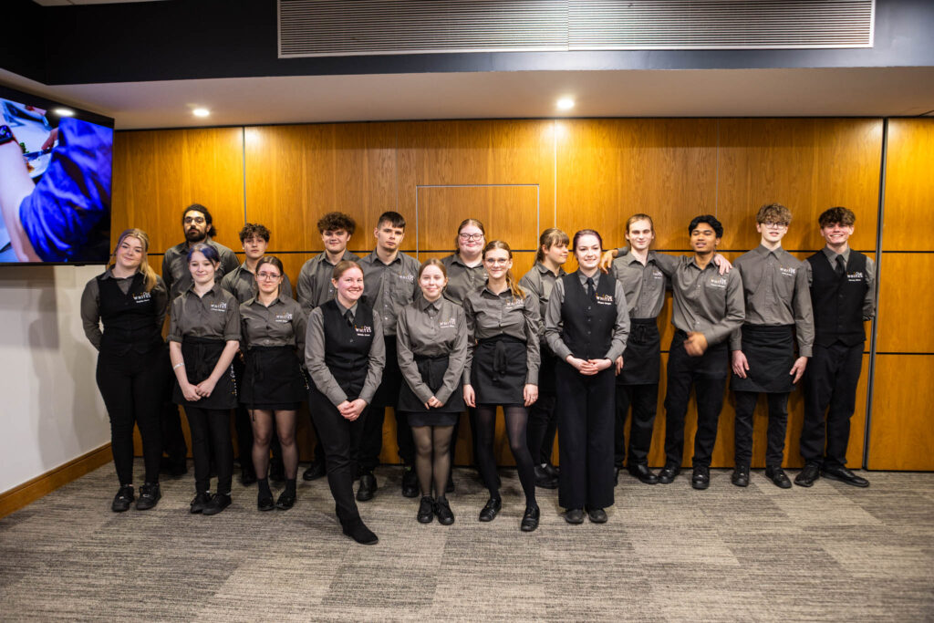 Group of Suffolk New College students posing together during the industry dinner event at Ipswich Town Football Club, showcasing student engagement and industry collaboration.