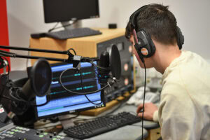 Student working with audio equipment in a digital media studio at Suffolk New College, part of the Digital Industries course.