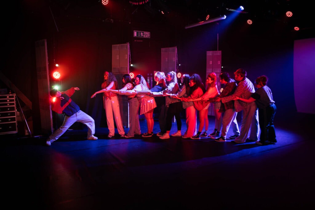 Students at Suffolk New College perform a dynamic scene inspired by Stranger Things, showcasing their drama and production skills in a vibrant theatre setting.