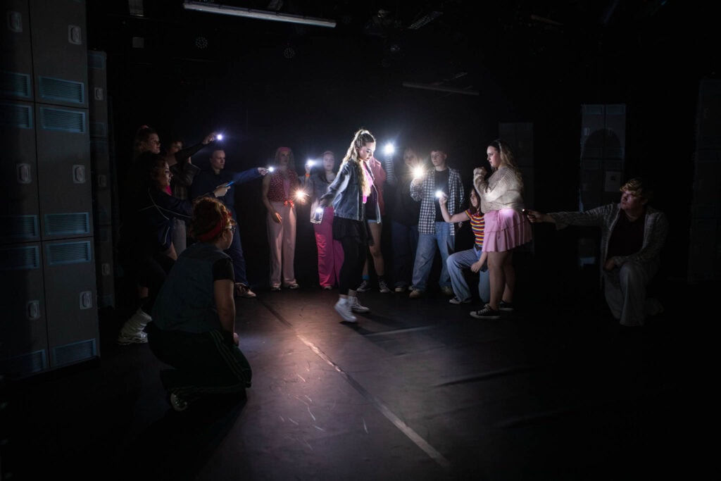 Students at Suffolk New College act out a scene inspired by Stranger Things, showcasing drama and production skills in a dark studio setting with dramatic lighting.