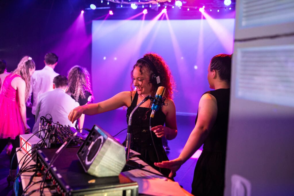 Students at Suffolk New College perform with DJ equipment during a production inspired by Stranger Things, showcasing creative media skills and college entertainment events.