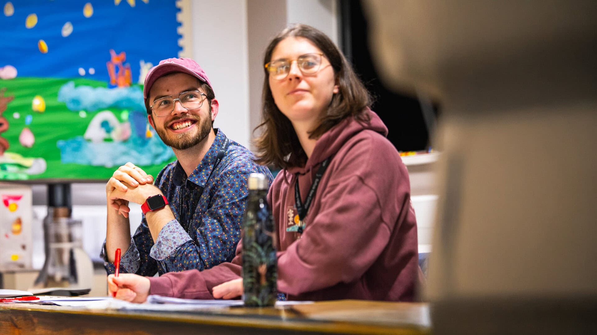 Two students at Suffolk New College engaging in a classroom activity, showcasing modern learning environment and student diversity for college education.