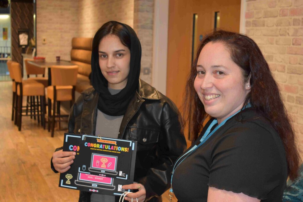 Two students at Suffolk New College smiling and holding a congratulatory certificate, showcasing student achievement and support services at the college.
