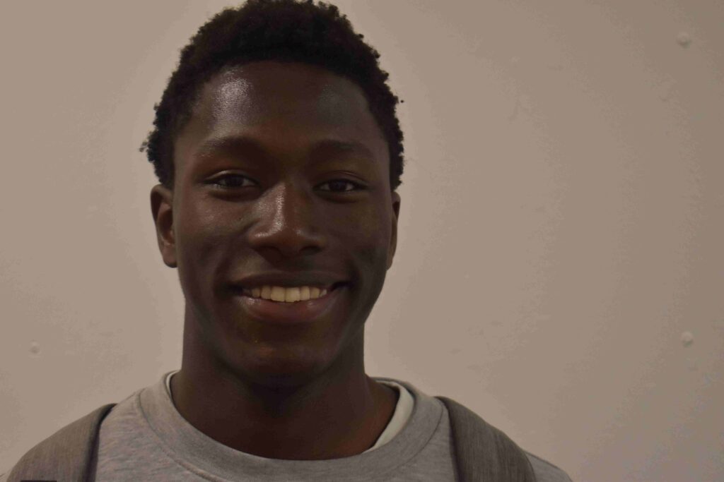 A young male student at Suffolk New College smiling, representing ambition and aspirations to play in the World Cup, during a college visit.
