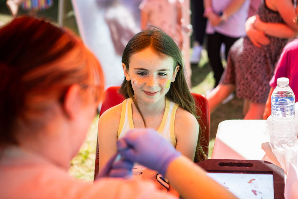 A young girl receiving a vaccination or health check at Suffolk New College during the family fun day event.
