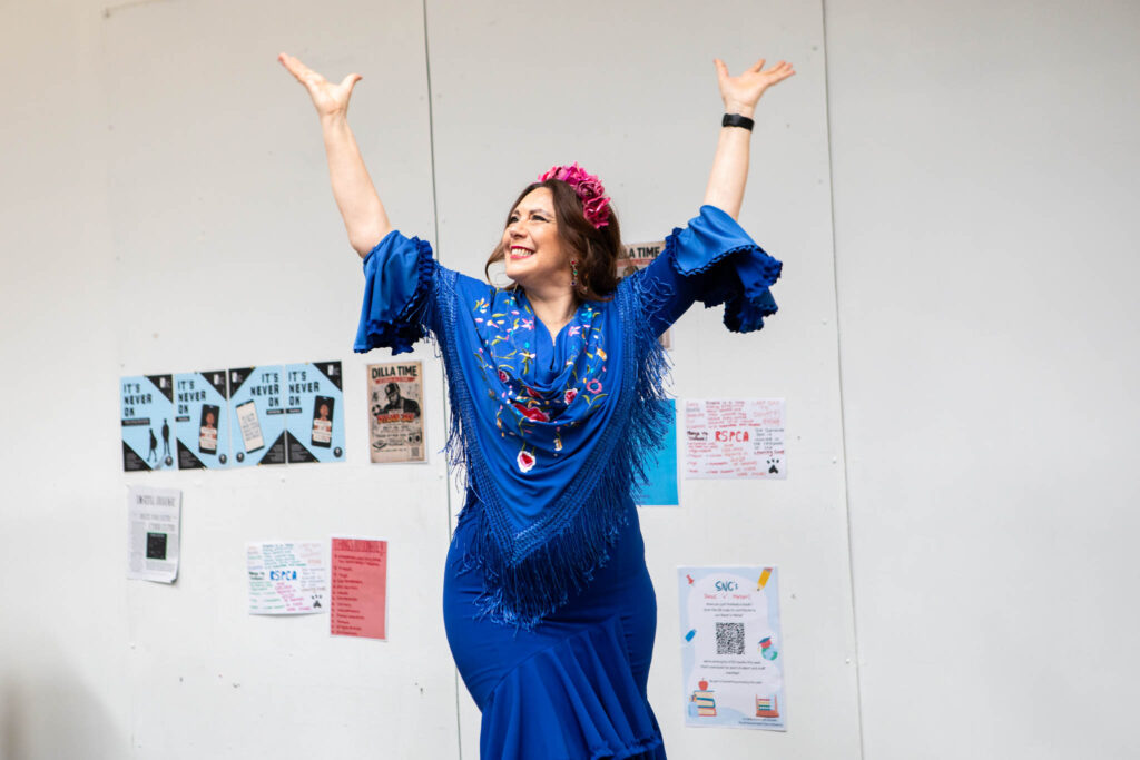 Happy student in vibrant blue dress and floral headband celebrating achievement at Suffolk New College, showcasing student success and vibrant campus life in Suffolk.