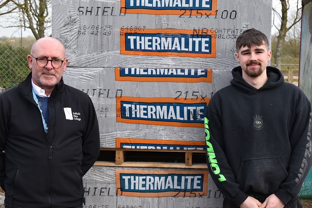 Two men standing in front of large thermal insulation materials with Suffolk New College logo, highlighting community support and donations from a construction firm.
