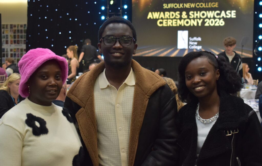 Three students at Suffolk New College Awards & Showcase Ceremony 2026, smiling and celebrating their achievements at the college event.