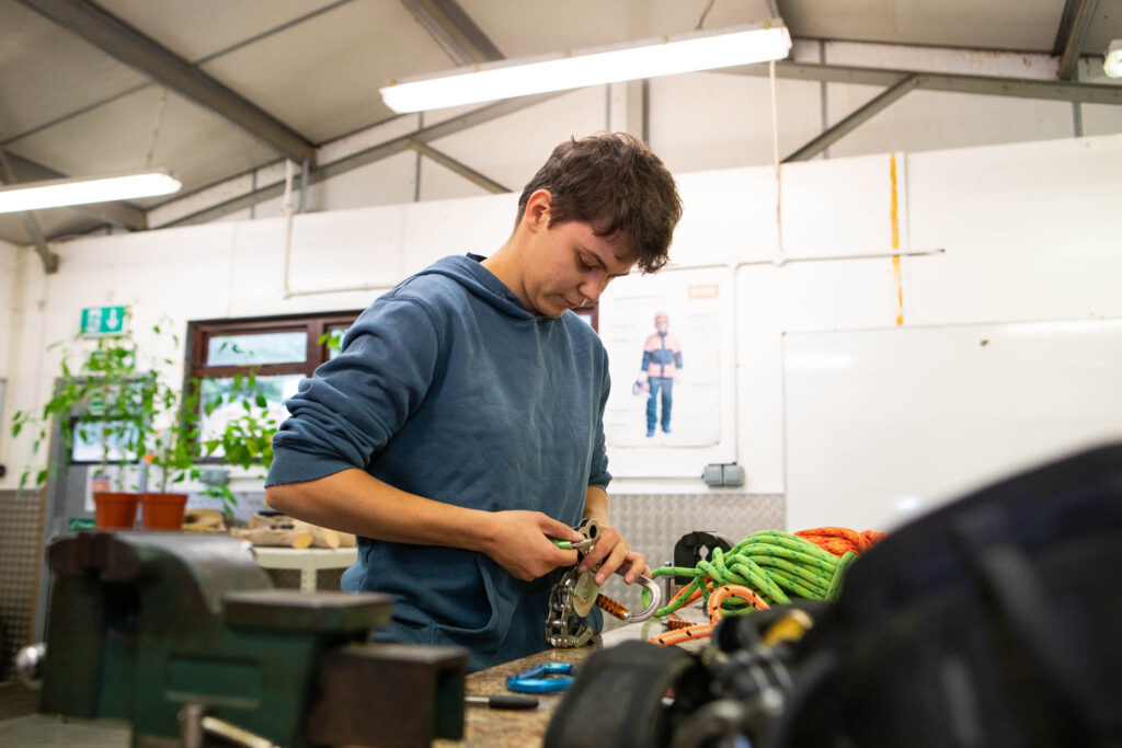 A land-based learner at Suffolk New College working with tools and equipment in a workshop setting, focusing on practical skills and hands-on learning.