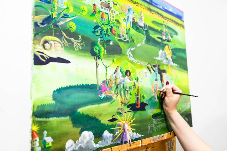 Student painting a colourful, detailed landscape mural at Suffolk New College, showcasing creative arts and design courses in a vibrant educational environment.