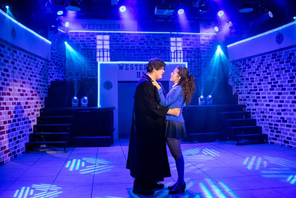 Two students performing a scene on stage at Suffolk New College, showcasing drama and performing arts education in a vibrant theatre setting.