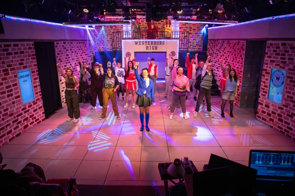 Students performing on stage at Suffolk New College theatre, showcasing drama and performing arts education in a vibrant, professional setting.