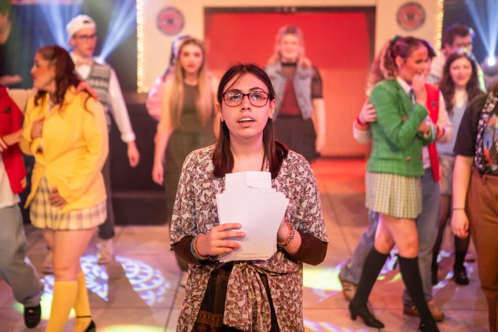 Group of students performing on stage at Suffolk New College, showcasing drama and theatre arts in a vibrant college environment.
