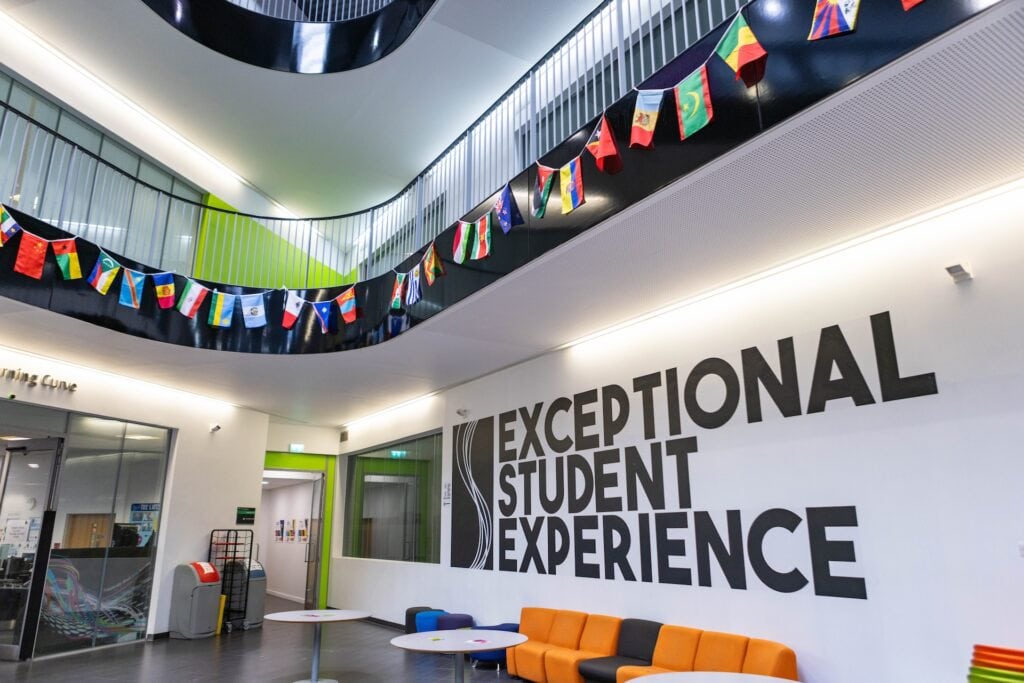 Modern student area at Suffolk New College with vibrant decor, seating, and a large wall sign reading 'Exceptional Student Experience' for a welcoming campus environment.
