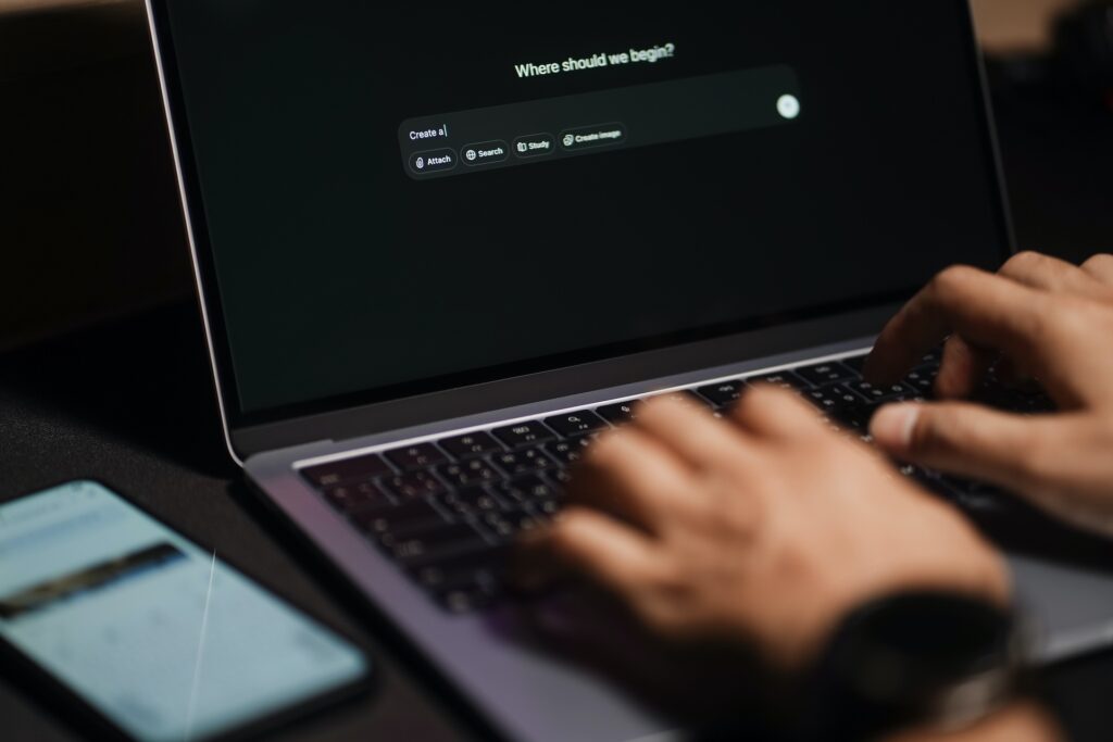 Person using a laptop with a search engine page titled 'Where should we begin?' in a modern workspace, representing innovation and technology at Suffolk New College.