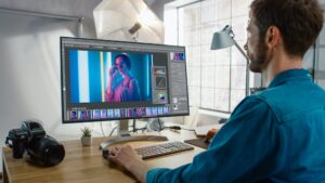 Photographer editing vibrant portrait in a professional studio, showcasing digital editing skills at Suffolk New College, Stowmarket Innovation Gateway.