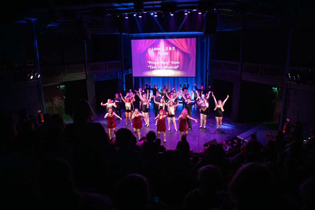 Students showcase creative dance performance on stage at Suffolk New College theatre during a college event.